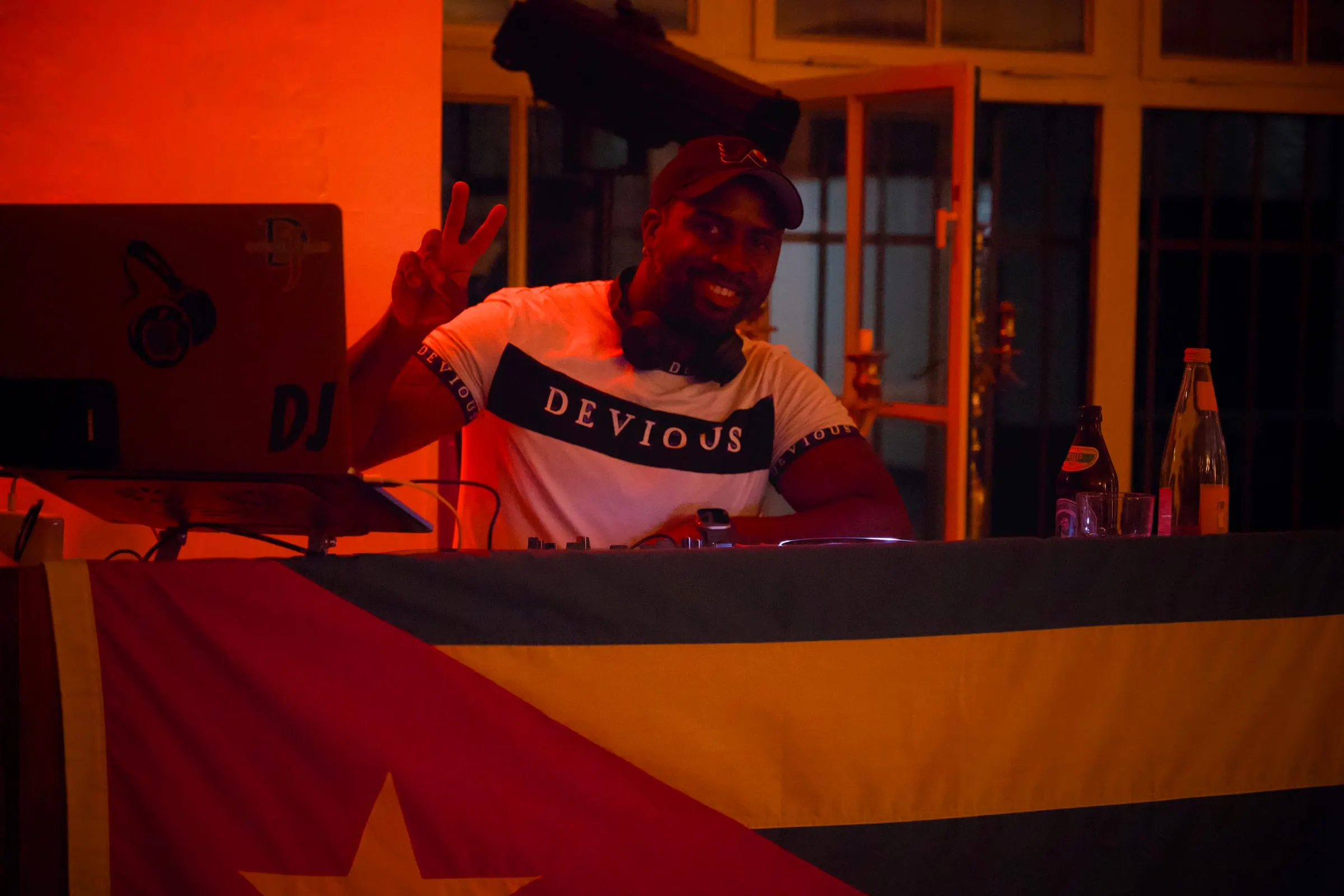 DJ legt kubanische Salsa auf, im Hintergrund die kubanische Flagge