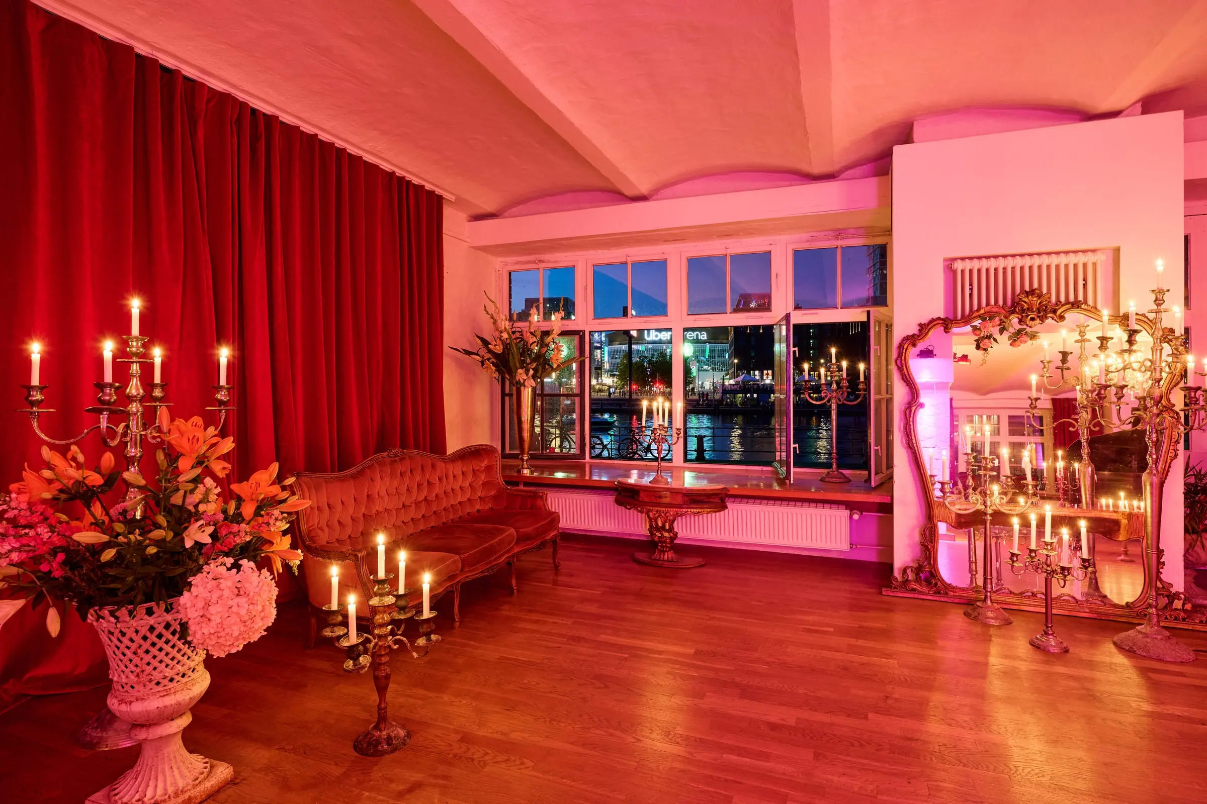Lounge mit Kerzenleuchtern und Blick auf die Spree bei Nacht